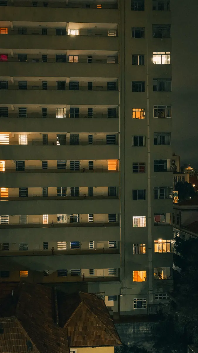 Wohnhochhaus bei Nacht mit erleuchteten Fenstern
