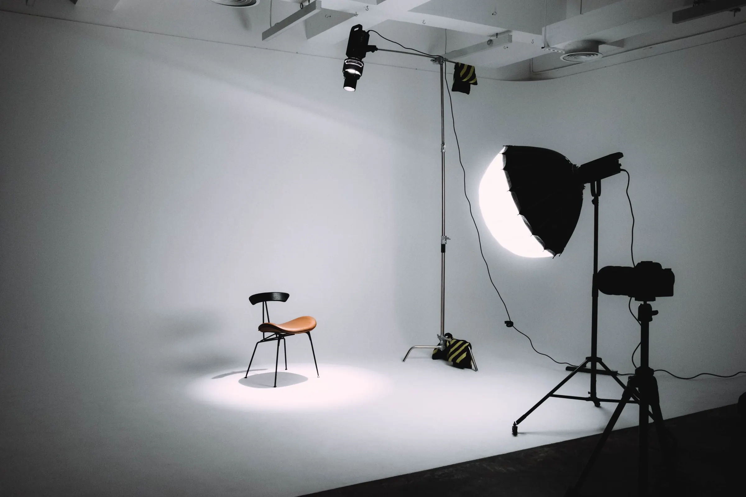 Leeres Fotostudio mit Leuchten, die auf einen einzelnen Stuhl gerichtet sind