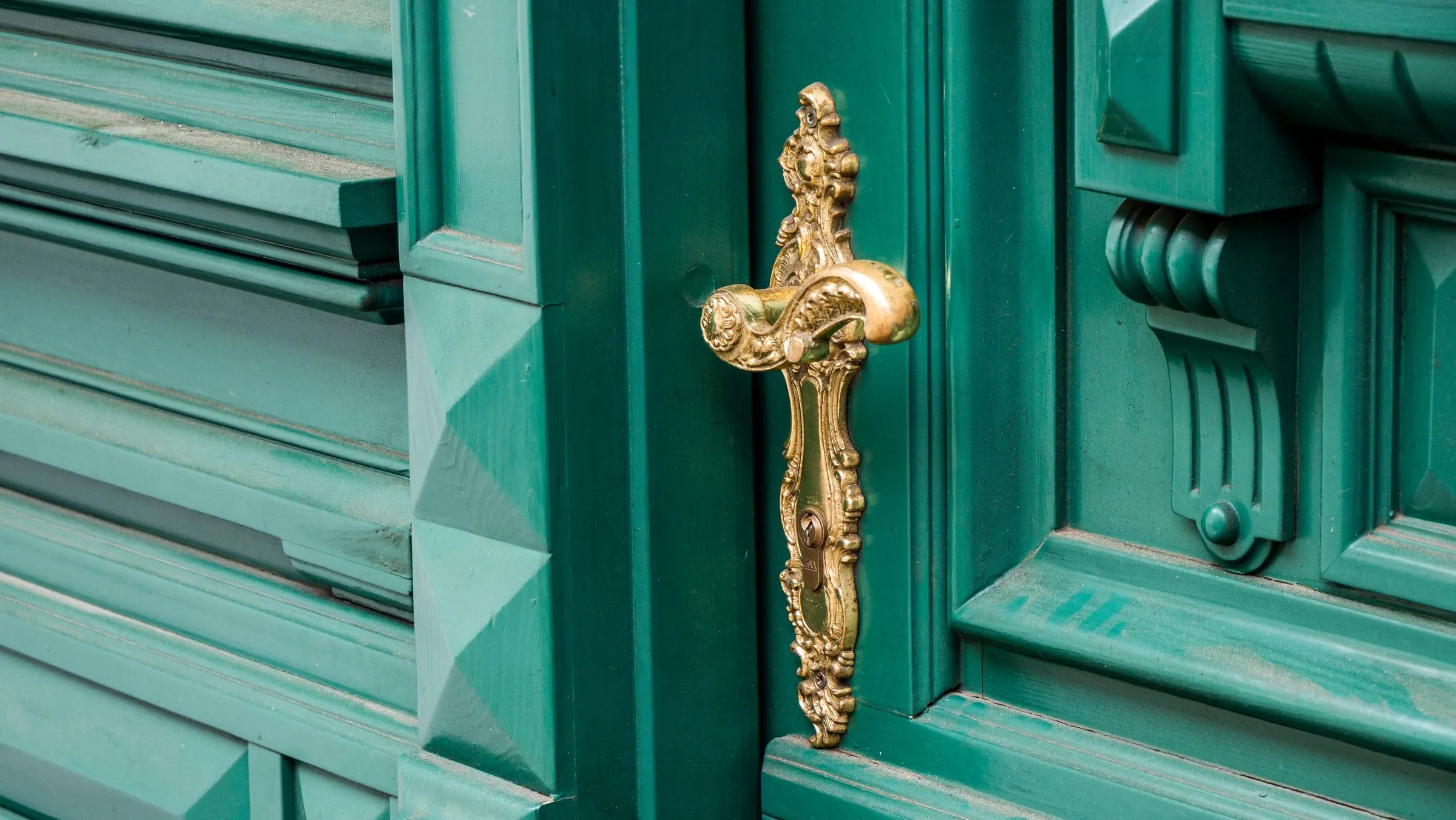 Türgriff aus Messing an einer kassettierten Holztür